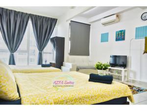 a hotel room with two beds and a television at AZFA Suite13 at De Centrum Putrajaya-Bangi in Kajang