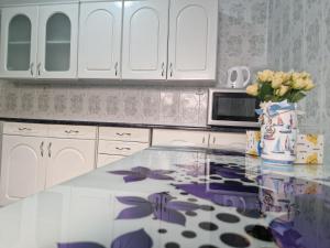 a kitchen with a counter with a vase of flowers at Vila Mondi in Eforie Nord