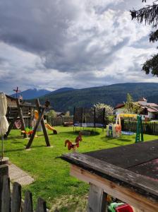 un parque infantil con equipo de juegos en el césped en Pension Lucknerhof en Maranza