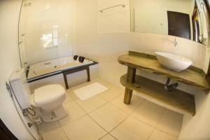 een witte badkamer met een wastafel en een toilet bij Hi Adventure in Florianópolis
