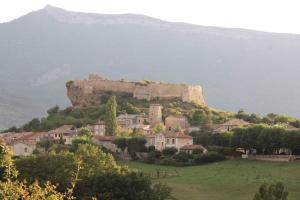 un castillo en la cima de una colina con casas en Le gîte de Marie, en Laragne
