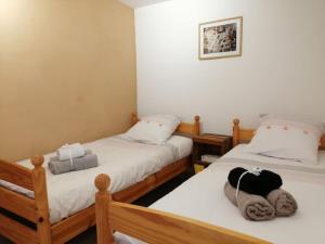 Habitación con 2 camas individuales y paredes blancas. en Le gîte de Marie, en Laragne