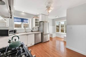 uma cozinha com armários brancos e um frigorífico de aço inoxidável em Pistakee Marina Boat House em Fox Lake