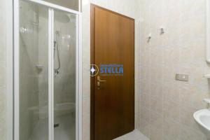 a bathroom with a shower and a wooden door at Costa Del Sol in Lido di Jesolo