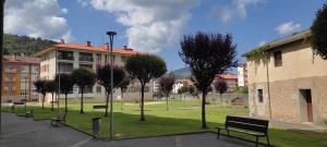 un parc avec bancs devant un bâtiment dans l'établissement Pilgrimshouse, à Marquina