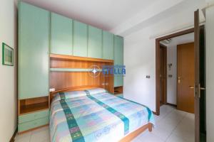 1 dormitorio con 1 cama con cabecero de madera en Costa Del Sol en Lido di Jesolo