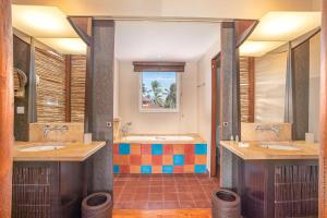 un bagno con due lavandini e due specchi di Emeraude Villas - Bay a Le François