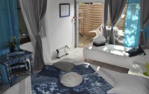 a bedroom with two beds and a window with a door at Hôtel Les Mimosas in Bormes-les-Mimosas