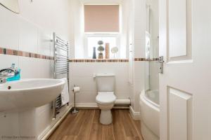a white bathroom with a toilet and a sink at Cosy Treat af Forest Chapel Holidays Ltd in Cinderford