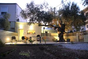 una casa con un árbol delante de ella en Bellisima Campagna Cabin Pelekapina - Chania Crete en La Canea