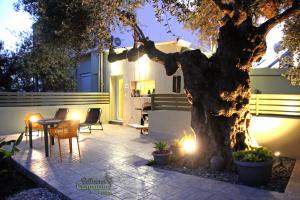 un patio con un árbol, una mesa y sillas en Bellisima Campagna Cabin Pelekapina - Chania Crete en La Canea