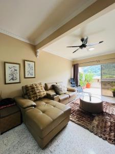 sala de estar con sofá y ventilador de techo en The Haven Suite en Bentong