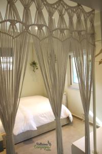 1 dormitorio con cama con dosel y cortinas en Bellisima Campagna Cabin Pelekapina - Chania Crete, en La Canea