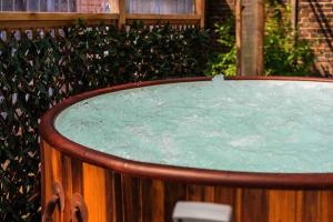 uma banheira de hidromassagem com água verde em frente a uma cerca em Contractor base with Hot Tub and Pool table em Londres