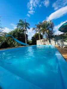 a blue swimming pool with a blue slide at chácara solar das águas in Socorro