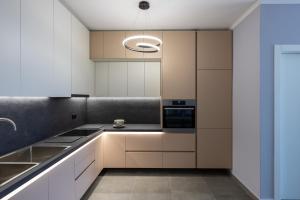 a kitchen with white cabinets and a black counter top at The view vanilla, Free Parking in Sarandë
