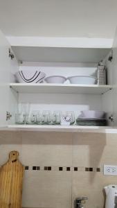 a kitchen shelf with plates and dishes on it at Alquiler por día. in Firmat