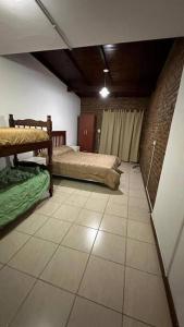 a room with two beds and a tiled floor at Alquiler por día. in Firmat