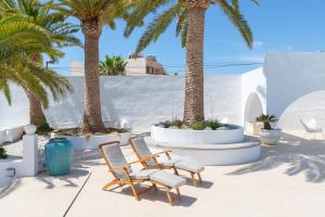 a patio with two chairs and palm trees at Luxury Mauresque Jazmin in Torremolinos