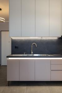 a kitchen with white cabinets and a sink at The view4- "Free Parking" in Sarandë