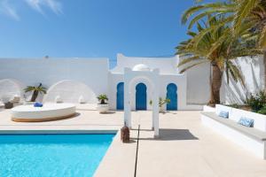 a white villa with a swimming pool and palm trees at Luxury Mauresque Jazmin in Torremolinos