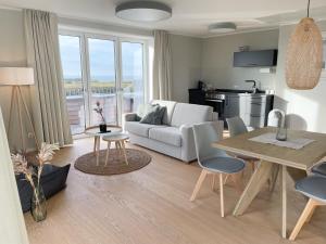 ein Wohnzimmer mit einem weißen Sofa und einem Tisch in der Unterkunft Westeroog in Wangerooge