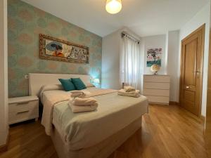 1 dormitorio con 1 cama con toallas en Los Amantes de Teruel con Parking Privado Incluido en Teruel