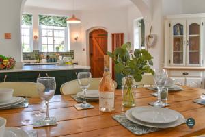 a wooden table with plates and wine glasses on it at The Old Chapel - Exclusive Retreat in Weymouth