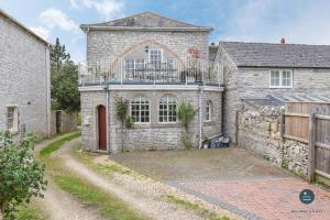 a stone house with a balcony on top of it at The Old Chapel - Exclusive Retreat in Weymouth