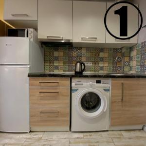 een keuken met een wasmachine en een koelkast bij Studio Aparment in Charkov