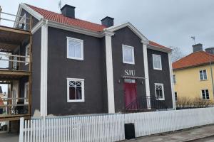 une maison noire avec une porte rouge dans l'établissement Centralt i Mariestad, à Mariestad