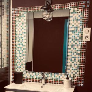 a mirror over a sink in a bathroom at Le Velo Rouge in Le Puy en Velay