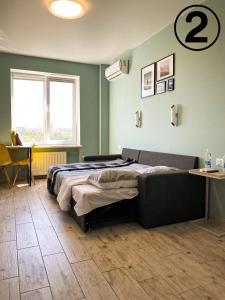 a bedroom with a bed and a table and a window at Studio Aparment in Kharkiv