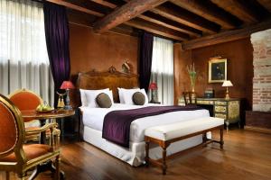 a bedroom with a large bed and a table and chairs at Palazzo Venart Luxury Hotel in Venice