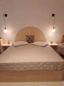 a bedroom with a large bed with two tables at Studios Irineos in Perissa