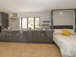 a kitchen with a couch in front of a counter at Bumble Bee Retreat in Axminster