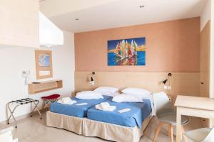 una camera con letto blu e tavolo e sedie di Achilleas Hotel Apartments a Città di Kos