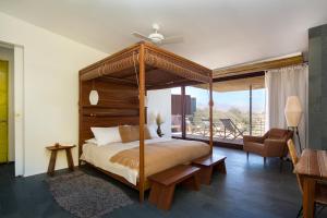 1 dormitorio con cama con dosel y sala de estar. en Tierra Atacama Hotel & Spa, en San Pedro de Atacama