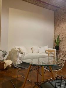 sala de estar con sofá blanco y mesa de cristal en Casa amplia, alegre y luminosa en Buenos Aires