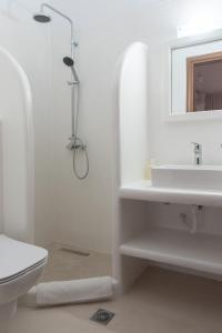 ein weißes Bad mit einer Dusche und einem Waschbecken in der Unterkunft So Nice Hotel in Marathokampos