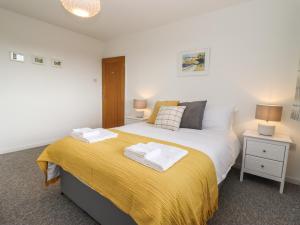 ein Schlafzimmer mit einem Bett mit einer gelben Decke in der Unterkunft Delabere Road in Bishops Cleeve