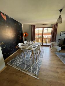 une salle à manger avec une table blanche et une grande fenêtre dans l'établissement Das Bergquartier - Ferienwohnung Rabenkopf, à Oberau