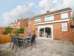 a patio with a table and chairs in front of a house at Delabere Road in Bishops Cleeve