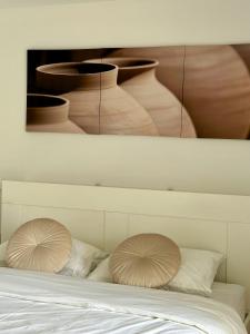 two pillows on a bed with vases on the wall at Serena at Athens Riviera in Vari