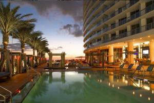 ハリウッドにあるOceanfront Condo Direct Ocean & Beach Club Accessのヤシの木が茂るホテルのスイミングプール、
