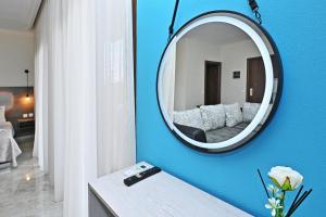 uno specchio su una parete blu in una stanza di Sinodinos Deluxe Apartments ad Áfitos
