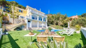 a large house with a yard with a pool at Costacabana - Villa Sunrise in Lloret de Mar