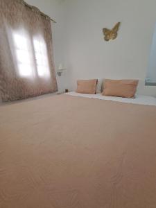1 dormitorio con 1 cama con una mariposa en la pared en Studios Irineos, en Perissa