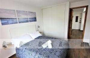 a bedroom with a bed and a painting on the wall at 508 Piscis Apartamentos - Apartamento recientemente reformado - Vistas a la montaña - Piscina y Playa in Benalmádena