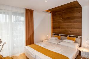 1 dormitorio con 1 cama grande y cabecero de madera en Hegyalja Étterem és Panzió, en Zsámbék